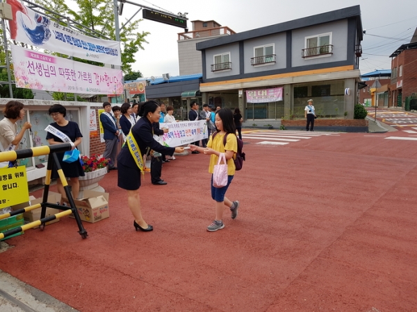 군위군녹색어머니회는 지난 18일 군위초등학교 앞에서 ‘등굣길 동시 어린이 교통안전캠페인’을 벌였다. 군위군 제공.