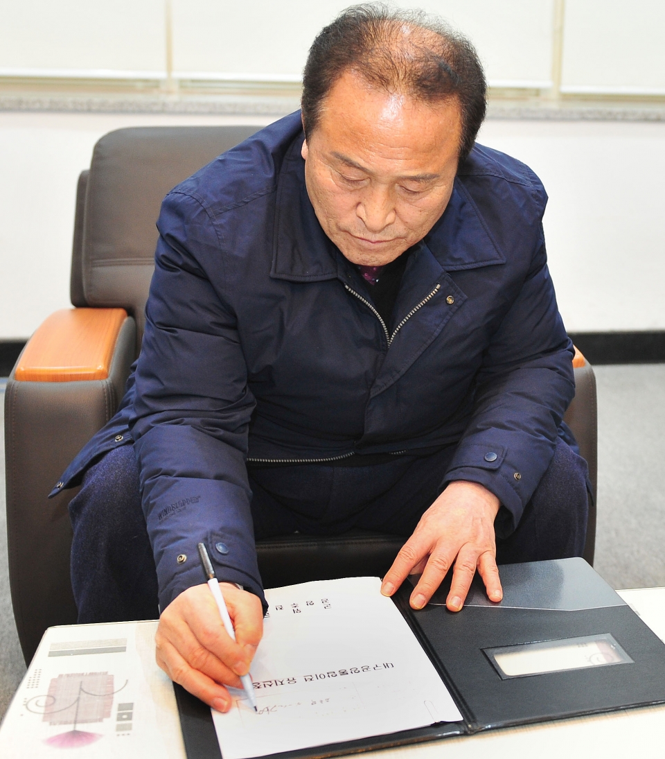 김영만 군위군수가 통합신공항 우보 유치 신청서에 서명하고 있다. 군위군 제공.