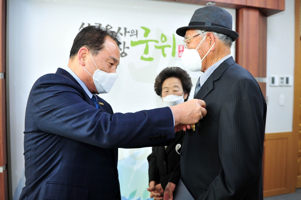 6·25전쟁 참전 용사인 김점경씨가 66년 만에 김영만 군위군수로부터 훈장을 전수받고 있다. 군위군 제공.